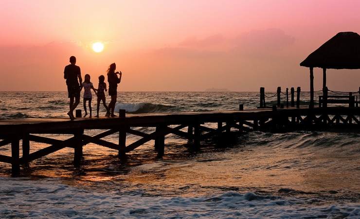 Famiglia in vacanza al mare durante un tramonto